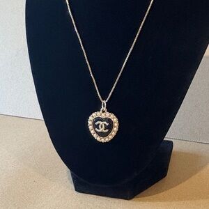 Heart shaped CC pendant in black with gold tone hardware and pearl like trim